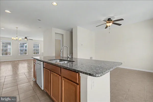 a view of empty room with wooden floor and ceiling fan