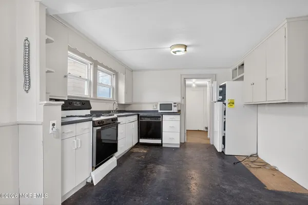 a kitchen with a refrigerator stove and white cabinets