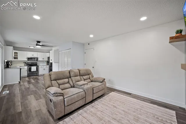 a living room with furniture and view of kitchen