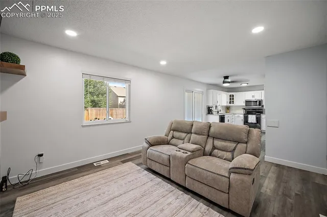 a living room with furniture and a wooden floor