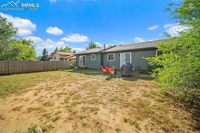 a view of a house with backyard and sitting area
