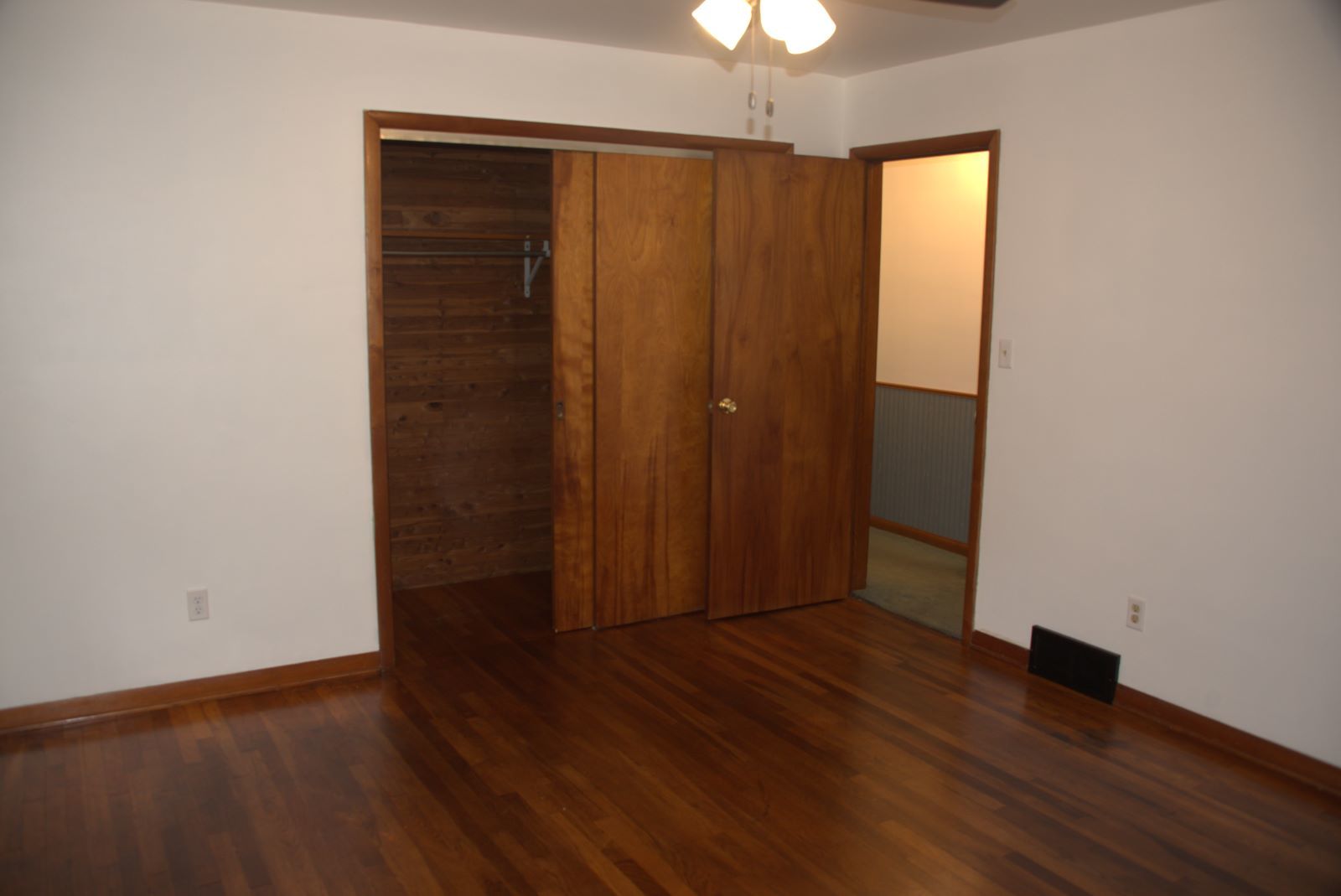 1921 East Steger Road Crete, IL 60417 - Photo 18 of 29 an empty room with wooden floor chandelier fan and closet area