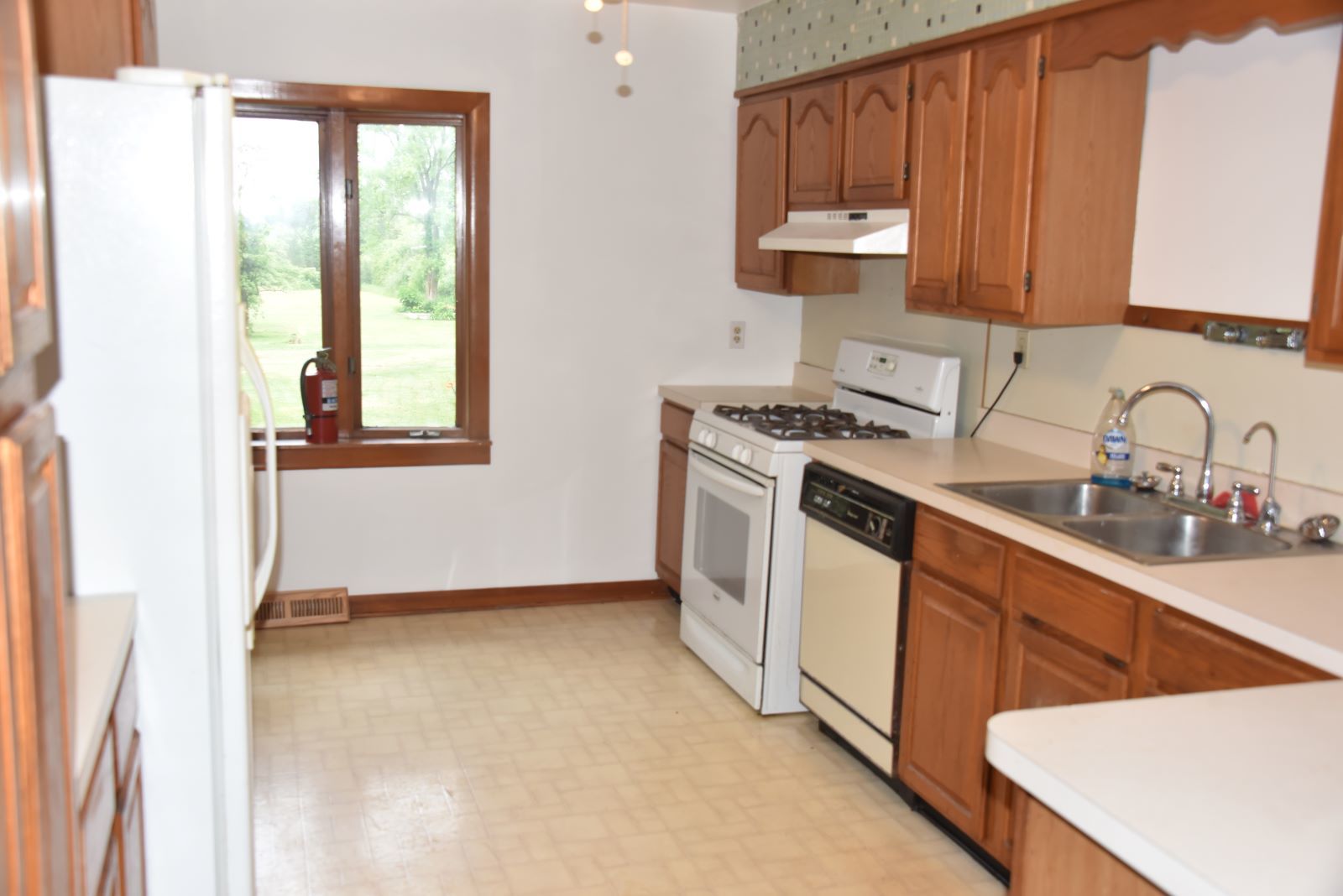1921 East Steger Road Crete, IL 60417 - Photo 10 of 29 a kitchen with stainless steel appliances a stove a sink a refrigerator with wooden cabinets and a window