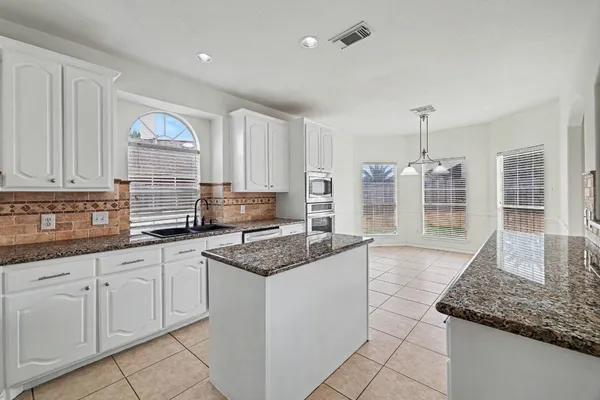 a kitchen with stainless steel appliances granite countertop a sink stove and cabinets