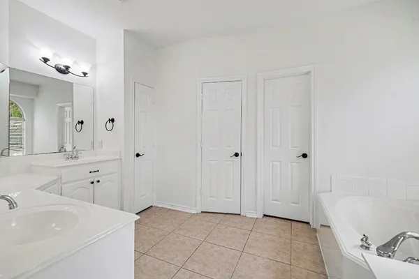 a spacious bathroom with a bathtub sink and mirror