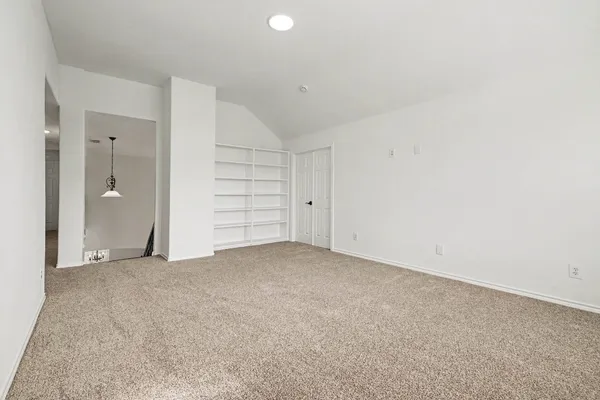 an empty room with a cabinet and mirrors