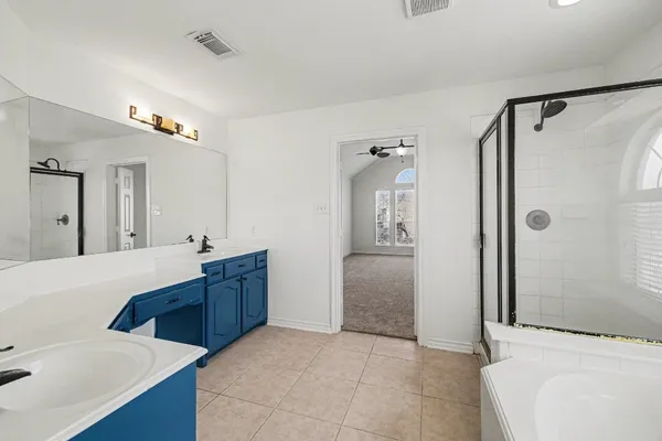 a bathroom with a tub sink shower and mirror