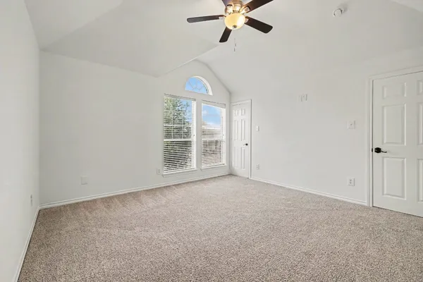 an empty room with windows and fan