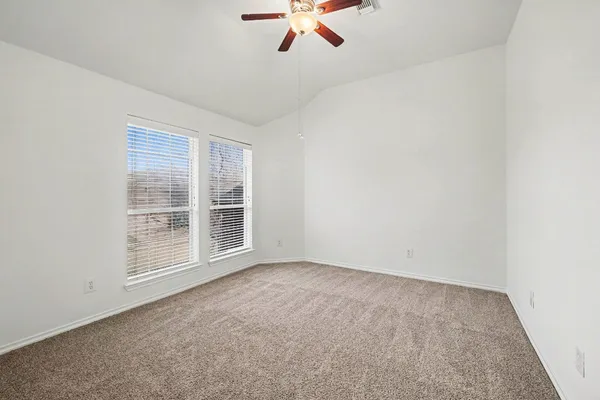 an empty room with a ceiling fan and window