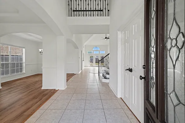 a hallway with wooden floor windows and stairs