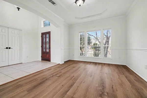 an empty room with wooden floor and windows