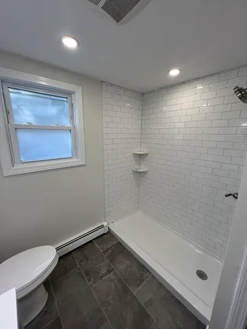 a bathroom with a toilet and a shower