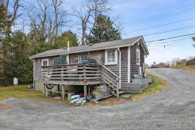 a view of a house with a small yard and wooden fence