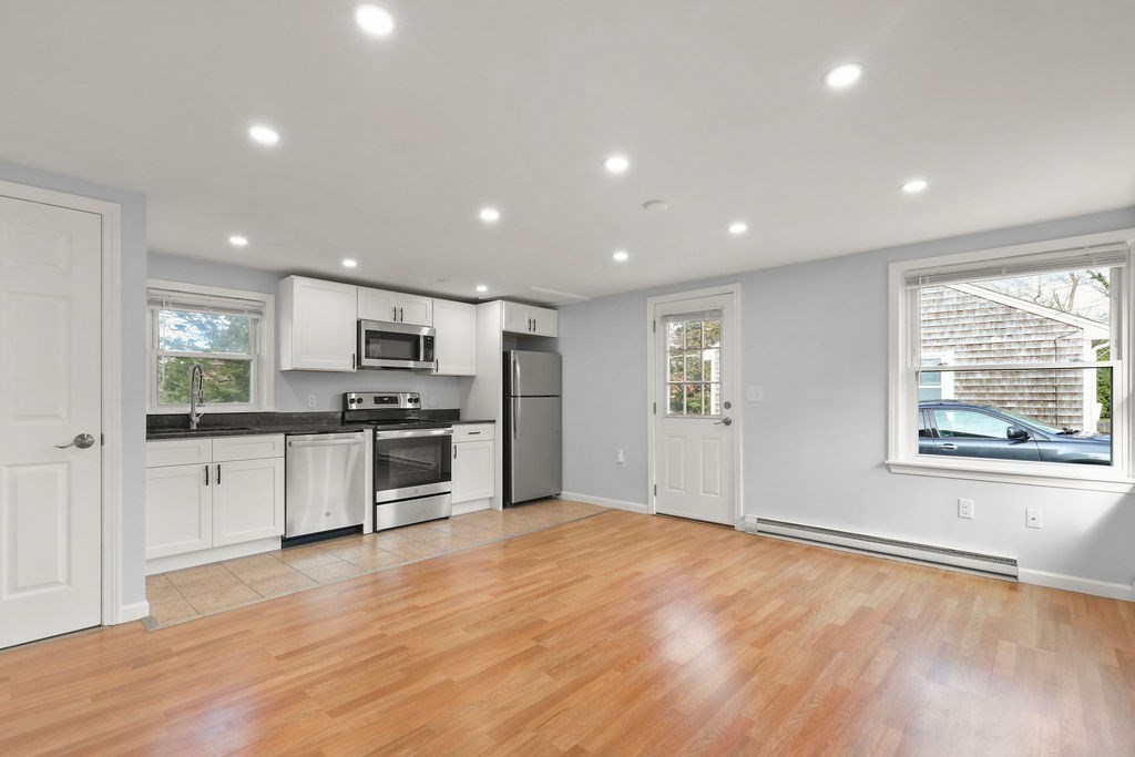 2705 State Highway Eastham, MA 02642 - Photo 5 of 42 a kitchen with stainless steel appliances kitchen island granite countertop a stove a sink and a refrigerator with wooden floor