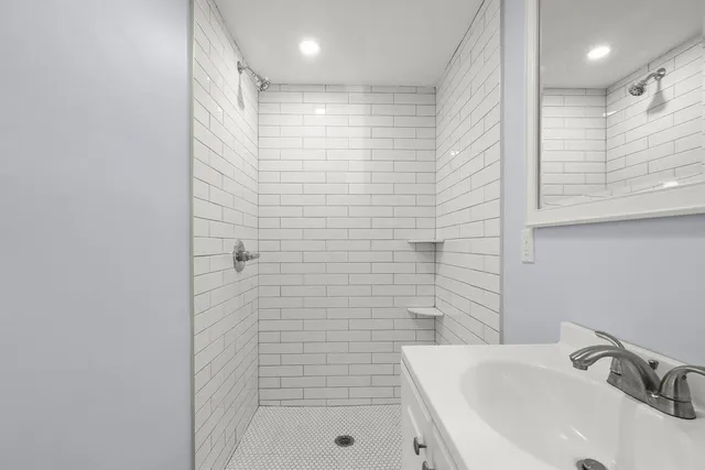 a bathroom with a sink a shower and a mirror