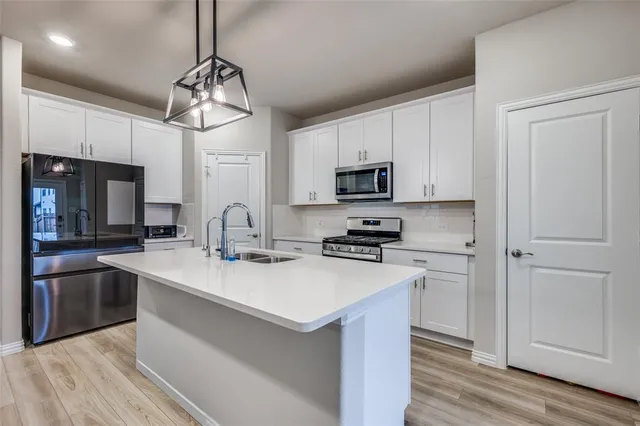 a kitchen with stainless steel appliances a sink stove and refrigerator