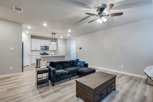a living room with furniture and a wooden floor
