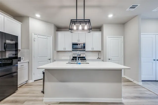 a view of a kitchen with center island stainless steel appliances and cabinets