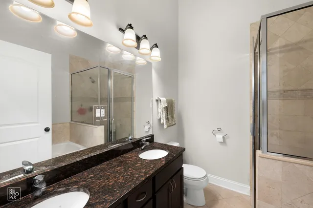 a bathroom with a granite countertop sink toilet and shower