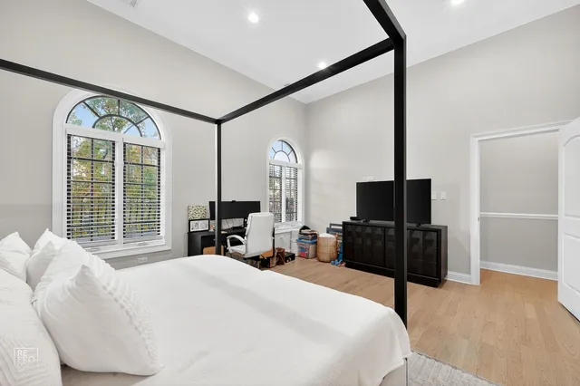 a bedroom with a bed window and a flat tv screen