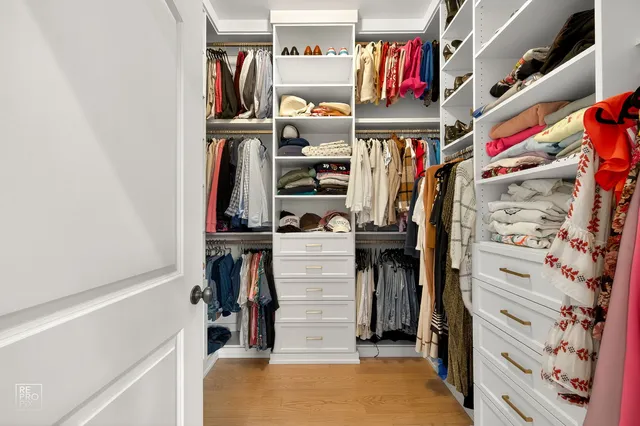 a view of walk in closet with clothes and shoes