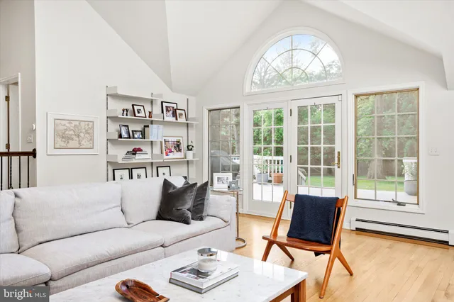 a living room with furniture a bookshelf and a large window