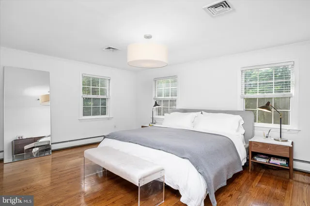 a spacious bedroom with a bed and wooden floor