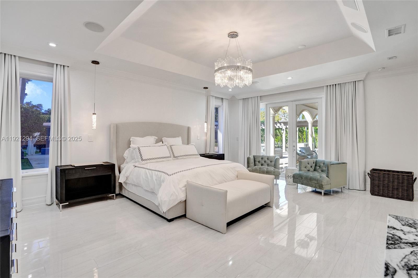 10400 Southwest 62nd Street Miami, FL 33173 - Photo 11 of 34 a spacious bedroom with a bed and a chandelier