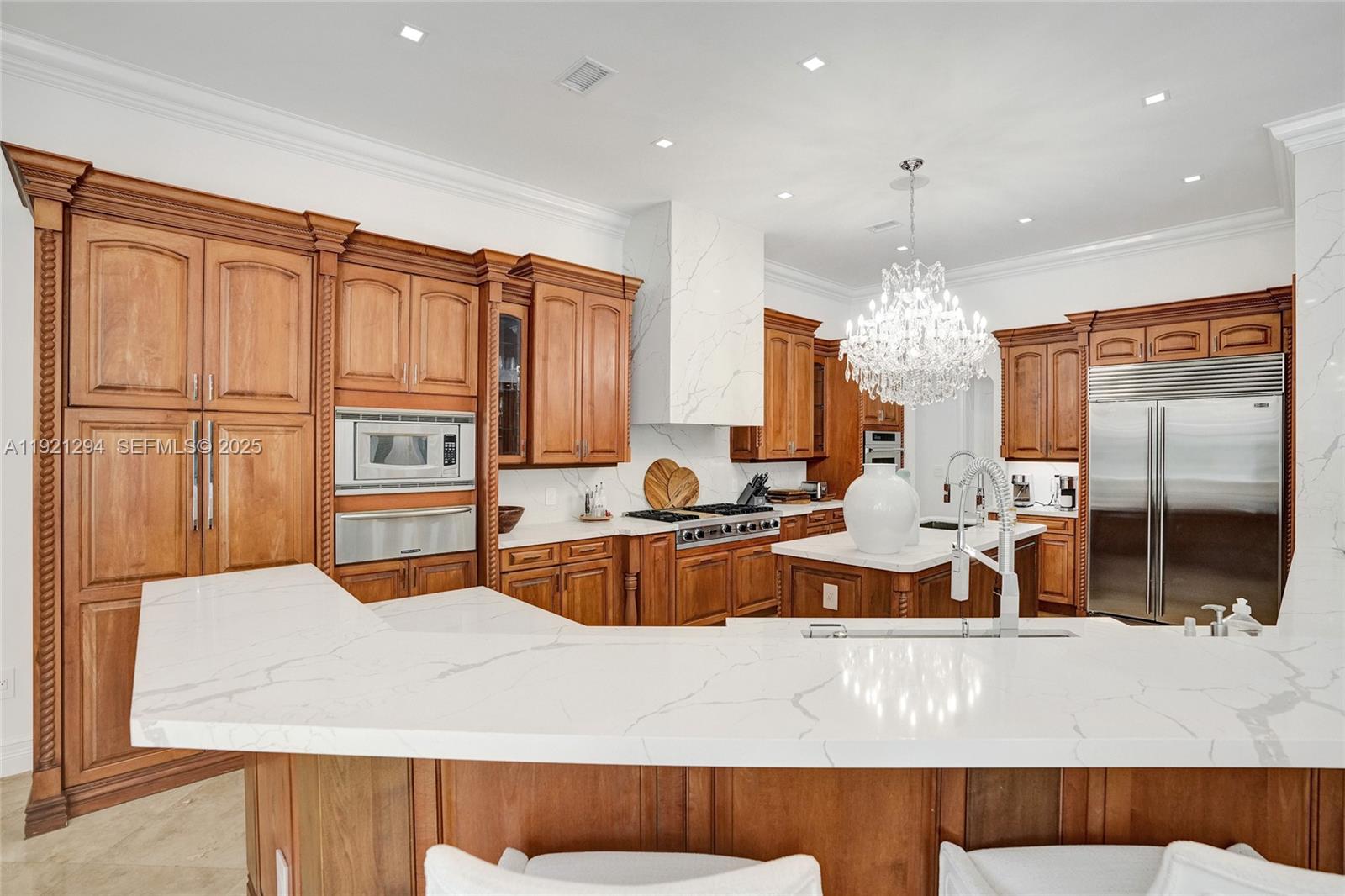 10400 Southwest 62nd Street Miami, FL 33173 - Photo 29 of 34 a large kitchen with kitchen island stainless steel appliances a stove a sink dishwasher and cabinets with wooden floor