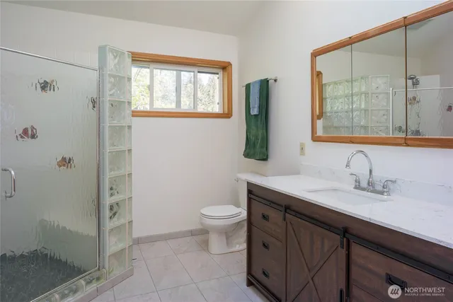 a bathroom with a granite countertop sink a toilet and a mirror