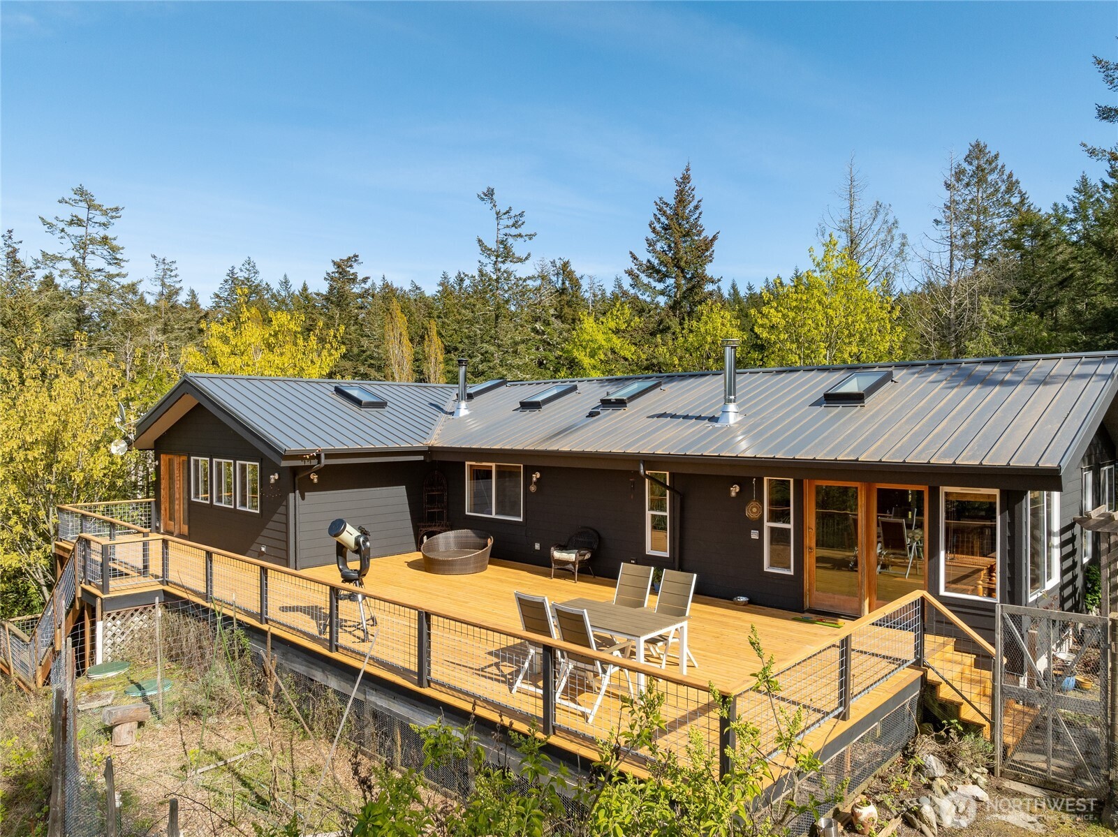 486 Wildwood Road Orcas Island, WA 98245 - Photo 3 of 37 a front view of a house with a yard glass top table and chairs