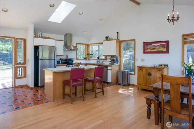 a room with stainless steel appliances kitchen island granite countertop furniture and a dining table
