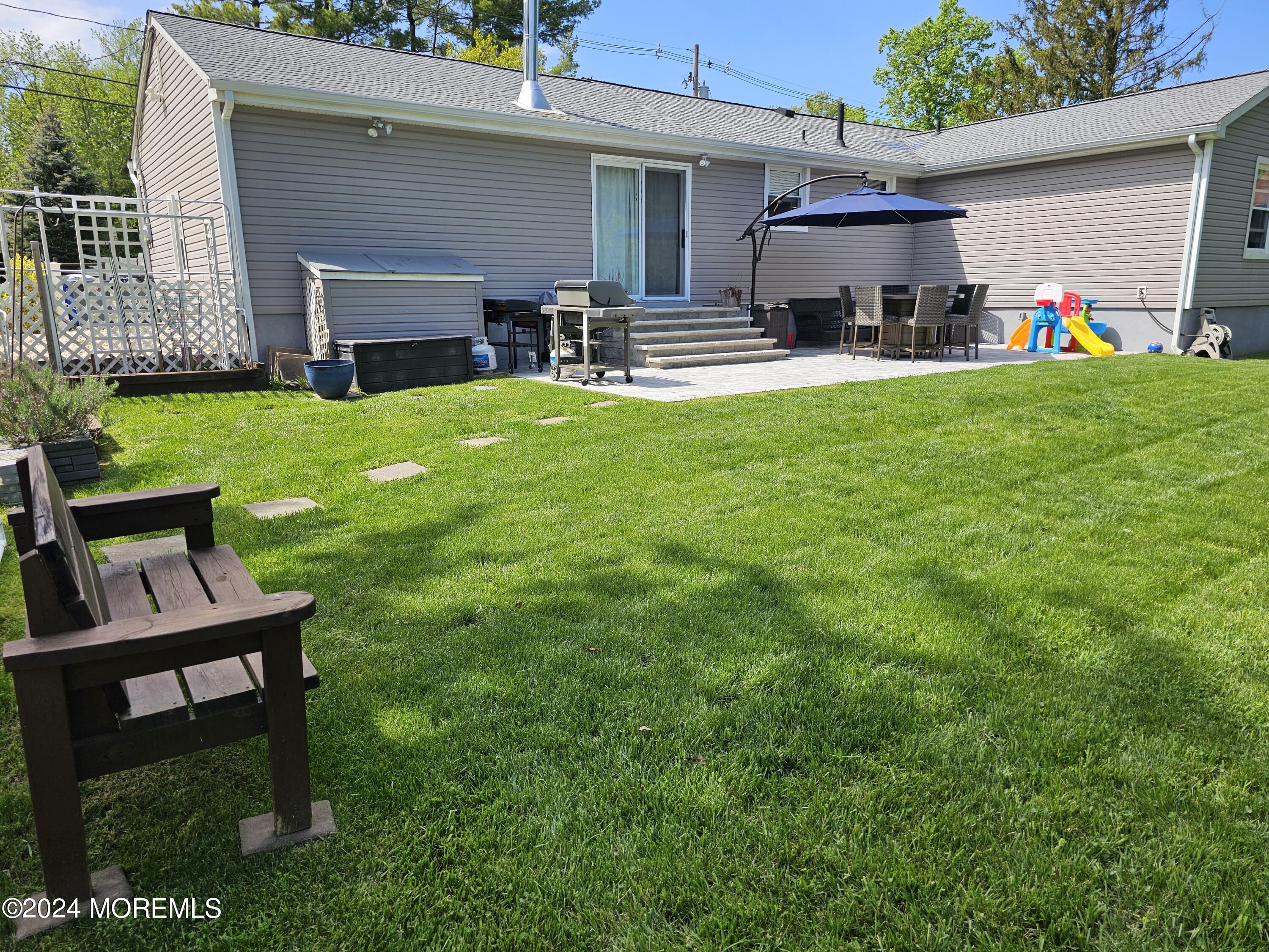 42 Middlesex Road Matawan, NJ 07747 - Photo 3 of 33 a view of a backyard with table and chairs and wooden fence
