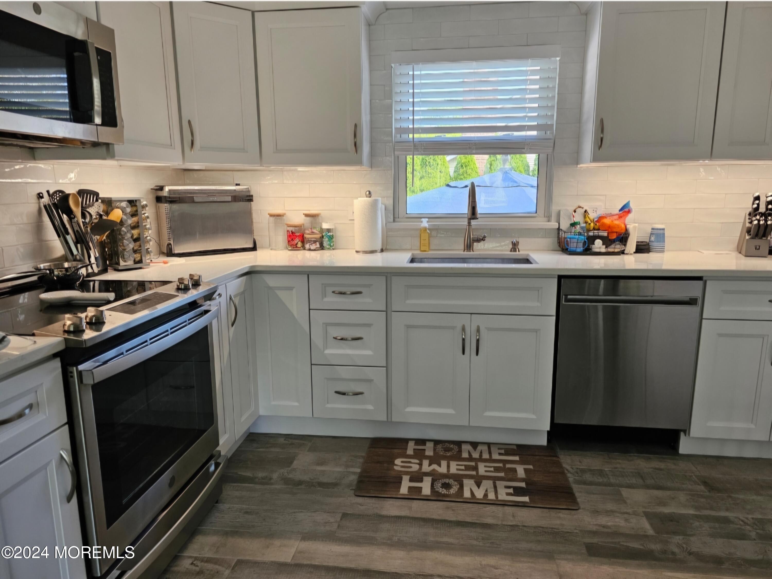 42 Middlesex Road Matawan, NJ 07747 - Photo 9 of 33 a kitchen with stainless steel appliances a stove sink and cabinets
