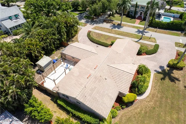 a view of a white house with a yard and potted plants
