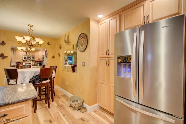 a dining room with furniture a chandelier and wooden floor