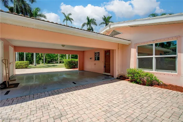 a front view of a house with a yard and potted plants