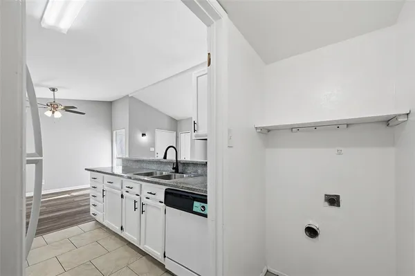a kitchen with a sink and white cabinets