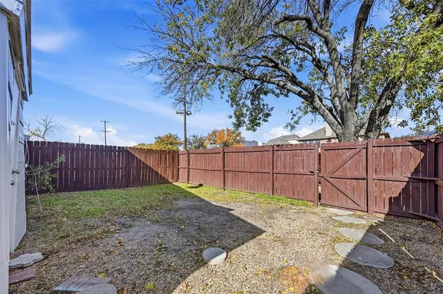 a view of backyard with wooden fence