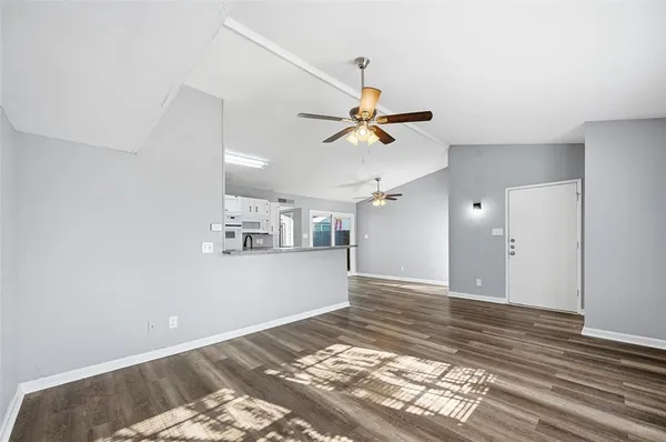 a view of a kitchen with a sink and dishwasher with wooden floor