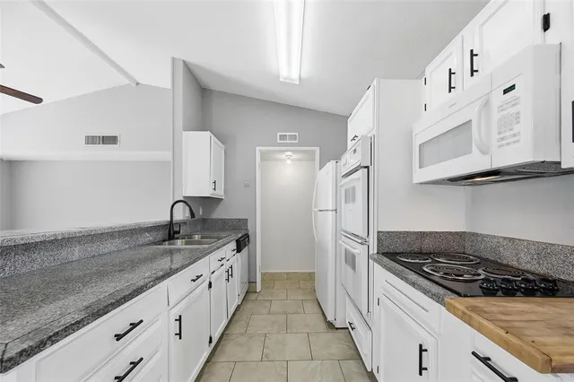 a living room with stainless steel appliances kitchen island granite countertop furniture a rug and a window