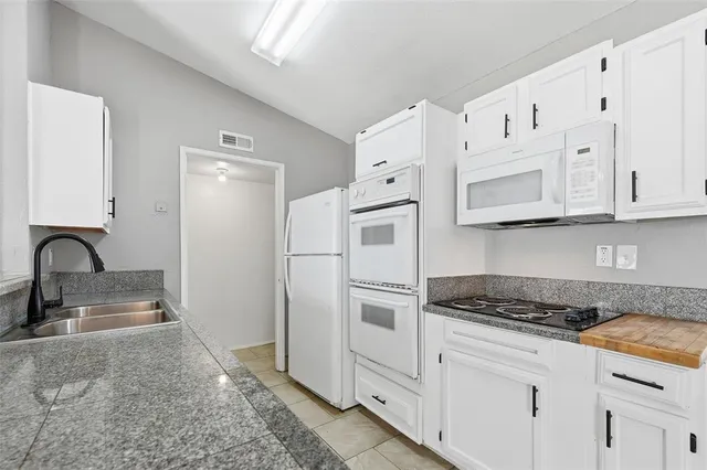 a kitchen with stainless steel appliances granite countertop a sink and a stove