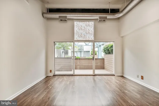 a view of empty room with wooden floor