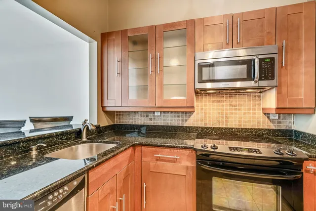a kitchen with stainless steel appliances granite countertop a refrigerator stove and microwave
