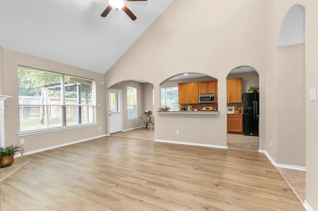 an empty room with a kitchen and windows