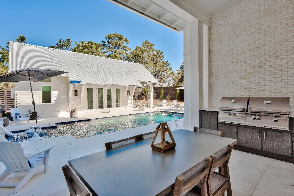 90 Sandstone Street Santa Rosa Beach, FL 32459 - Photo 13 of 73 a kitchen with a table chairs and a stove