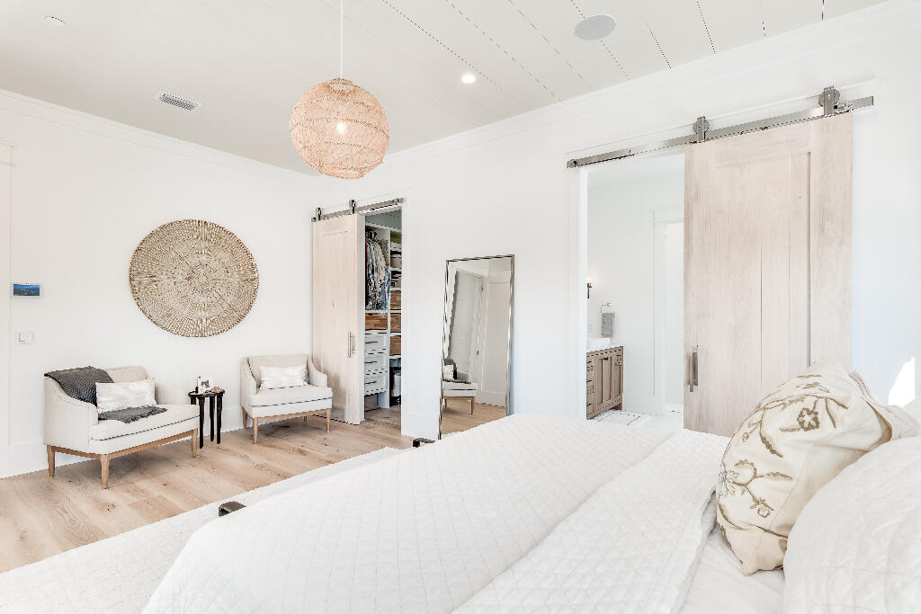 90 Sandstone Street Santa Rosa Beach, FL 32459 - Photo 30 of 73 a bedroom with a large bed and a chandelier