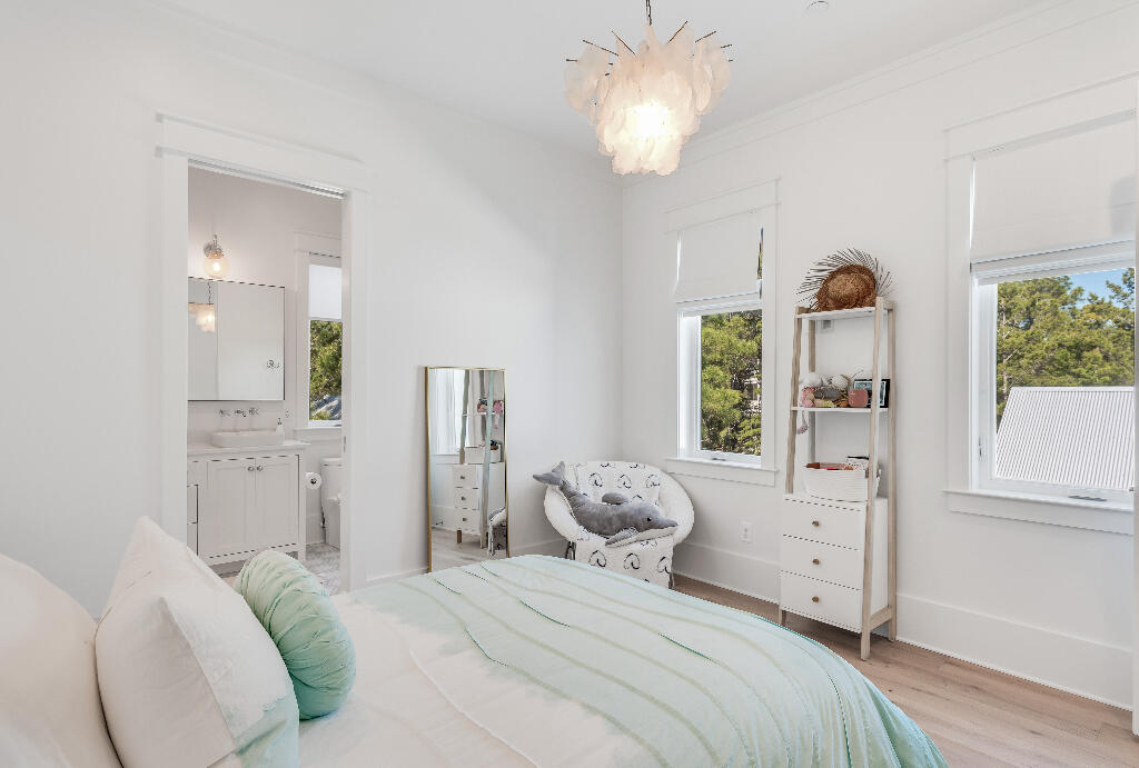 90 Sandstone Street Santa Rosa Beach, FL 32459 - Photo 37 of 73 a bedroom with a bed and a chandelier