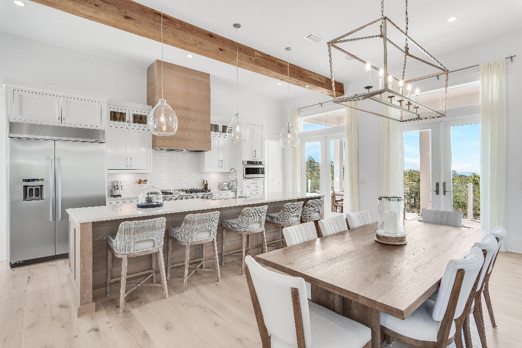 90 Sandstone Street Santa Rosa Beach, FL 32459 - Photo 53 of 73 a kitchen with stainless steel appliances a table and chairs in it