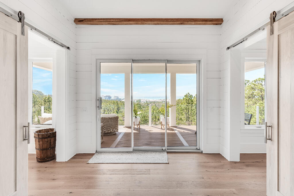90 Sandstone Street Santa Rosa Beach, FL 32459 - Photo 68 of 73 a view of empty room with wooden floor and floor to ceiling window